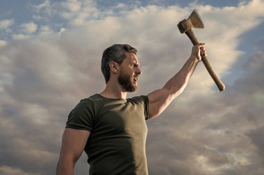 confident man with axe. strong caucasian man hold ax. brutal man on sky background.