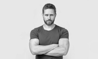 Sakallı, kendine güvenen beyaz bir adamın fotoğrafı. Kirli sakallı beyaz adam tişört giyiyor. Gri arka planda sakallı beyaz bir adam var. Stüdyoda sakalı olan beyaz bir adam..