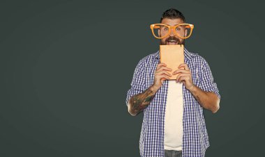 Parti gözlüklü komik sakallı adam kitabı tutuyor..