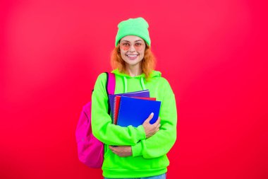 Üniversitede ya da üniversitede ev ödevi yapan genç bir kız öğrenci pembe üzerine izole edilmiş..