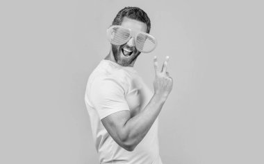 Yazlık gözlüklü gülümseyen parti adamının fotoğrafı. Sarı gözlüklü parti adamı. Arka planda gözlüklü bir parti adamı. Stüdyoda gözlüklü bir parti adamı..