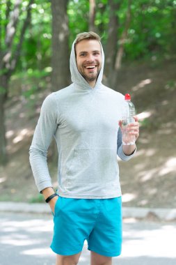 Susadım. Plastik şişeli genç bir adam. Sağlıklı bir yaşam tarzı. Vücutta su elektrolit dengesi. Günde bir içki. Sıvı yeterliliği. Susuz kalma. Susamış sporcu. Adam maden suyu tutuyor..