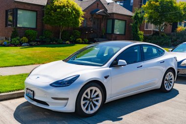Seattle, WA, ABD - 3 Temmuz 2024: Tesla model 3 beyaz lüks evin yanında.