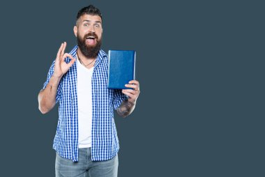 Mutlu sakallı adam gri arka plan hakkında kitap tavsiye ediyor. Tamam.