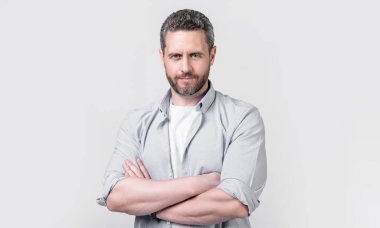 Sıradan bir gömlek giyen karizmatik beyaz bir adam. Gri arka planda izole edilmiş günlük tarzda beyaz bir adam. Stüdyoda kirli sakalı olan sıradan bir beyaz adam. Kafkasyalı adamın resmi. Rahat giyin..