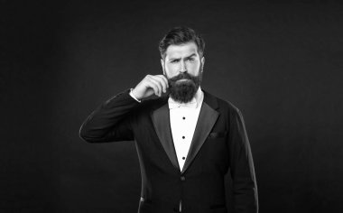 serious man in tuxedo bow tie with moustache. man in formalwear on black background. male formal fashion.