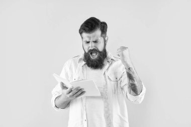 shouting hipster guy reading notebook on yellow background, success.