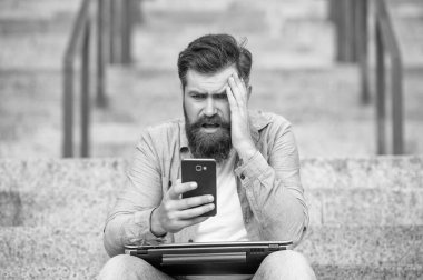 Hayal kırıklığına uğramış adam bahsi kaybetti. Sinirli adam cep telefonuyla bahis sonuçlarını kontrol ediyor. Mobil cihazda bahis oynuyorum. İnternet üzerinden bahis oynuyorum. Akıllı telefondaki mobil uygulamaları kullanarak bahis oynamak. Kumar..