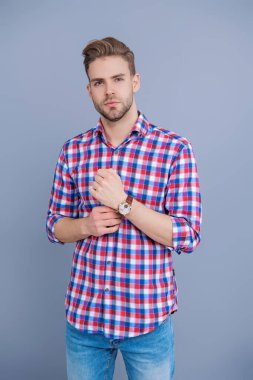 Millennial yakışıklı adam kol saatini gösteriyor. Erkekler için moda aksesuarı. Erkek moda aksesuarı. Eli kollu bir adam. Stüdyoda kol saatini gösteren bir adam. Zaman dakikliği. Lüks kol saati olan adamlar..