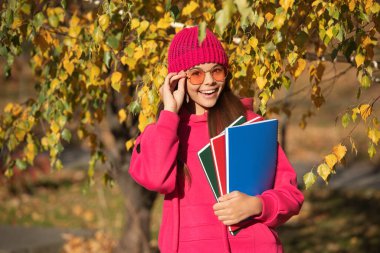 Okul bilgisi. Okula dönüyorum. Sonbahar kızı okul ödevini tutuyor. Ergenlik bilgisi. Sonbaharda açık havada genç bir kız. Sonbahar ders çalışma zamanıdır. Bilgi ve eğitim. Eğitim kaynakları.