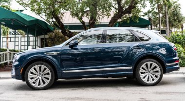 Miami Beach, Florida USA - 10 Haziran 2024 Bentley Bentayga Miami Beach Ocean Drive Caddesi. Blue Bentley Bentayga okyanus yolculuğunda.