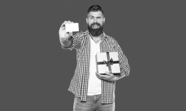 Olgun sakallı, hediye kutusu ve kartı olan bir adam..