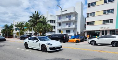 Miami Beach, Florida USA - 8 Haziran 2024: 2023 Porsche Panamera 4 platin baskı beyazı Miami sahilinde. Ocean 'daki lüks araba porshche Miami plajına gidiyor..