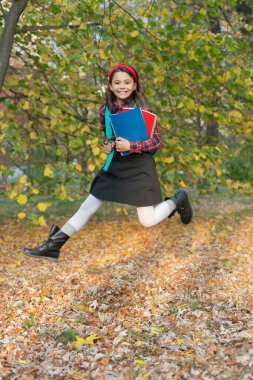 Bilgi toplama günü. Sonbahar okulu ödevinde atlayan kız. Okula dönelim. Ödevi olan genç kız sonbahar parkında zıplıyor. Açık hava okulunda kız eğitimi. Bilgi ve eğitim. Sonbahar indirimi.