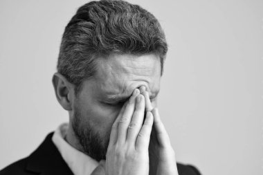 Yorgun adam baş ağrısından muzdarip. İş sorunları. Baş ağrısı migreni. Migreni olan takım elbiseli bir iş adamı. İş adamının ağrısı yüzünden migreni tuttu. İş Kaygısı.