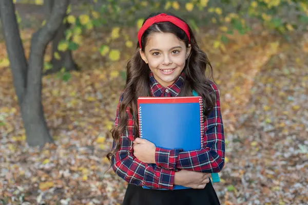 stock image Girl in autumn hold school homework. Back to school. Teen girl with homework in autumn. Student hold homework. School education of girl outdoor. Knowledge and education. Knowledge day. School uniform.