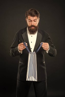 Smokinli, papyonlu, siyah fonda resmi kıyafet giyen, iş ödülü olarak alışveriş torbasında olan hayret verici bir adam. özel selamlama.