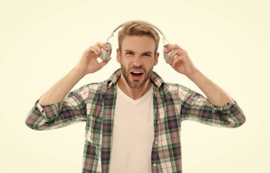 Genç adam müzik yüzünden iyi duyamıyor. Beyaz stüdyoda izole edilmiş müzik için kulaklıklarını çıkaran adam. Müzik dinlemek, birinin söylediklerini duymamak..
