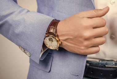 Eli kollu bir adam. Kol saatini gösteren bir adam. Son teslim tarihi. Zaman yönetimi. Erkek kol saati. Lüks hayat ve başarı. Erkek moda aksesuarı. Gerçek zarafet.