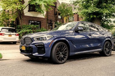 New York City, ABD - 26 Ağustos 2023: BMW X6 SUV mavi renk, köşe kenarı manzaralı.