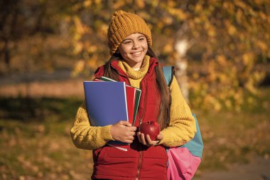 smiling teen girl back to high school in autumn.