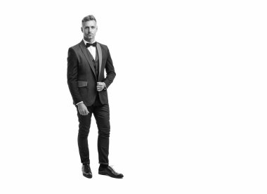 Beyaz arka planda boyun yayı olan smokin giymiş iş adamı. tam uzunluk.