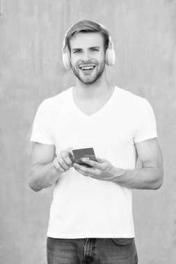 Neşeli adam mp3 müzik listesini beyaz gömlekle seçiyor. İnsan mp3 müzik listesinin kulaklıkla fotoğrafı. Adam mp3 müzik listesini açıyor. Adam dışarıda mp3 müzik listesi kullanıyor.