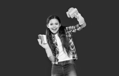 Genç temizlikçi kız kırmızıda izole edilmiş ev işleri yapıyor. Temizlikçi kız stüdyoda ev işi yapıyor. Temizlikçi kız arka planda ev işleri yapıyor. Temizlikçi kızın fotoğrafı süngerle ev işi yapıyor..