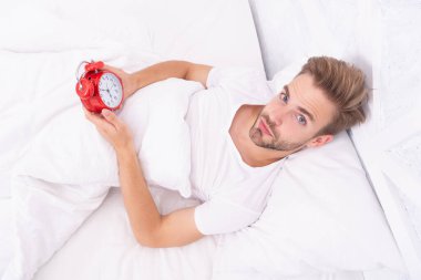 Uykulu adam çalar saati kapatıyor ve sabah erken kalkıyor..