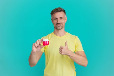 Erkek güzellik kozmetiği. Erkek kozmetik ürünü sunan adam. İzole edilmiş yüz kremi gösteren adam. Olgun adam cilt kremi kullanır. Günlük alışkanlık ve kişisel bakım. Cilt güzelliği. Cilt esnekliğini arttır.