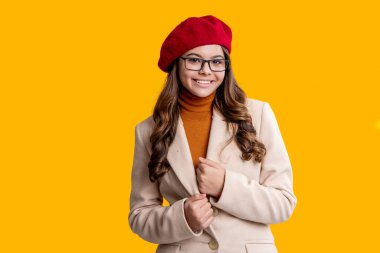 Kız sonbaharda şık görünüyor. Gençlik modelinin sonbahar havası. Sonbahar moda kızı sarıda izole edilmiş. Moda ve şık bir kız. Gözlüklü ve bereli sonbahar kızı. Sonbahar sezonu. Dış giysi beyanı.