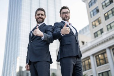İş başarısı. İş ortağı dışarıda. Takım elbiseli iki işadamı. İş ortaklığı. En iyi ortaklık. Ortak takım. Proje ortağı. Başarılı iş adamları. Başarılı bir ortaklık. Başparmak yukarı..