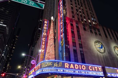 New York City, ABD - 24 Aralık 2023: Radio City Rockettes Christmas Spectacular müzikholde. Radio City müzikholünün neon ışıkları. Mutlu Noeller. Radyo binasında Noel ağacı.