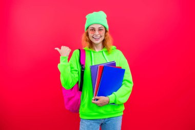 Okul eğitimi. Modern eğitim. Kız öğrenci çalışma kitabını tutuyor. Okula dönelim. Bilgi toplama günü. Üniversitede eğitim. Pembe üzerine izole edilmiş bir kızın ödevi. Bilgi ve eğitim. İşaret parmağı.