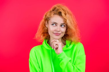 Pembe üzerine izole edilmiş şık bir kadın. Hareketli moda kız kapüşonlu giyer. Moda kıyafetleri ve tarzı. Kazaklı beyaz bir kadın. Sıradan bir yaşam tarzı. Havalı kapüşonlu giyen kızıl saçlı kız. Eğilim Ayarlayıcı.