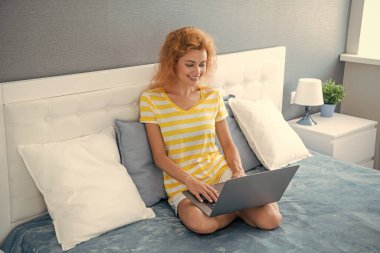 Evde dizüstü bilgisayarla çalışan mutlu bir kız. Serbest çalışan bir kız evde çalışıyor. Serbest çalışan biri için ev işi. Dizüstü bilgisayarı olan bir kız..