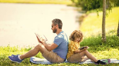 Baba ve oğul için aile eğitimi. Baba, oğlunun eğitici yolculuğuna ilham veriyor. Baba oğul parkta rahatlayın. Okul eğitimi. Oğlu ve babası yazın kaynaşıyorlar. Eğitimsel Babalık.