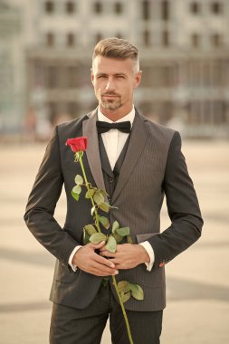 Romantik zamanlarda smokinli şık bir adam. Romantik hediyeli bir adam. Güllü karizmatik romantik bir adam..