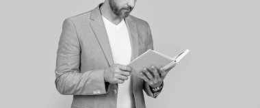 İnsan okuyucusunun sarı arka planda izole edilmiş kitap okuyuşunun kırpılmış görüntüsü. Adam okuyucu ceketinde kitap okuyor. Stüdyo fotoğrafında insan okuyucu kitap okuyor. İnsan okuyucunun kitap okurken çekilmiş fotoğrafı.