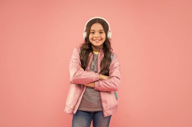 Online eğitim. Okula dönüyorum. Kulaklıklı mutlu kız. Müzik dinle. Kablosuz kulaklık cihazı aksesuarı. Yeni teknoloji. Çocukluk gelişimi. Sırt çantalı, modern kulaklıklı çocuk..