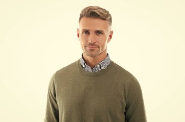 Beyaz arka planda sakallı, sırıtan olgun, kır saçlı bir adam. Gri kazaklı adam. Boz adamın sakalı var. Grimli adamın stüdyo çekimi.