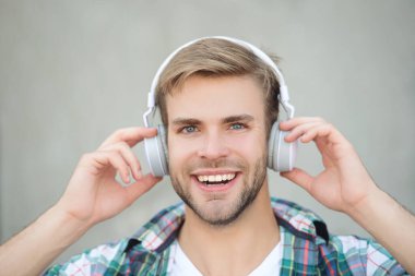 Milenyum adamı açık havada müzik dinler. Modern yaşam tarzı. Öğrenci hayatı. Kulaklıkla müzik dinle. Milenyum kuşağı sesi dinler. Müzik aşığı yaşam tarzı. Rahatlatıcı melodiler. Yüz resmi.