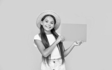 positive teen girl with copy space on orange paper on yellow background.