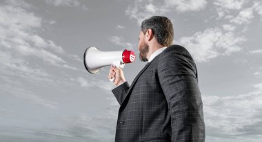 İş adamı gökyüzü arkaplanında hoparlörden anons yaptı.