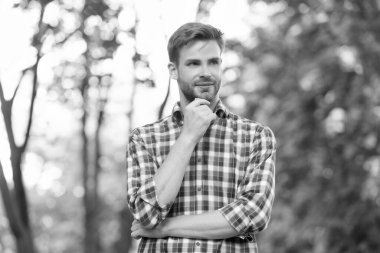 Dışarıdaki kareli gömlekli neşeli genç adam..