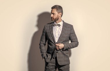 Gri arka planda smokinli beyaz adam. Stüdyodaki smokinli adam. Smokin giyen adamın fotoğrafı. Erkekler smokin giyer..