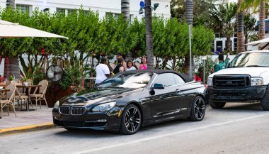 Miami Beach, Florida USA - June 5, 2024: BMW 650i xDrive Convertible at ocean drive miami beach. BMW 650i xDrive Convertible black. clipart