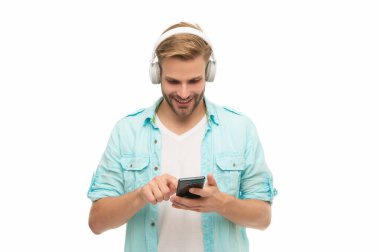 Müzik yaşam tarzı. Ses çalma listesi. Kulaklıklı adam. Kulaklıklı adam telefonda mp3 çalma listesini seçiyor. Akıllı telefon uygulamasını beyazlar içinde kullanan adam. Telefonla müzik dinlemek. İnternette sohbet..