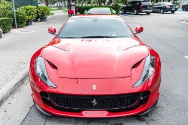 Miami Beach, Florida USA - 9 Haziran 2024: 2019 Ferrari Portofino Miami plajında kırmızı. Ferrari lüks bir İtalyan markasıdır. ön görünüm