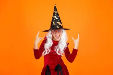 Bütün cadılar kendini iyi hisseder. Yarasa şapkası. Cadılar Bayramı cadı kostümlü kız. Mutlu Cadılar Bayramı. Cadılar Bayramı kostümlü cadı kız turuncu üzerine izole edilmiş. Şeker mi şaka mı? Tüm Cadılar Bayramı kostüm partisi kutlaması.